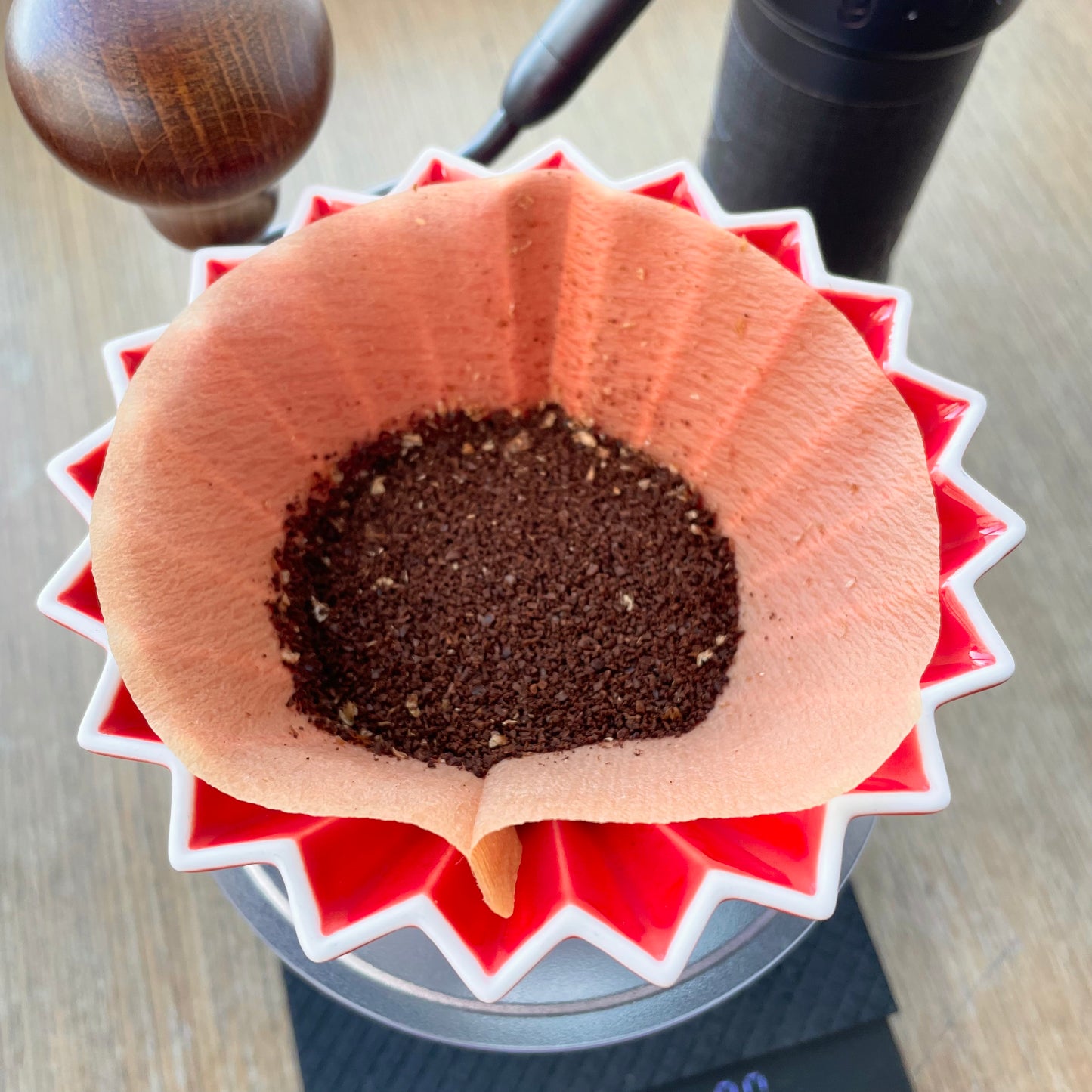 Filtered coffee set up with freshly grinded coffee ground poured into an origami filter